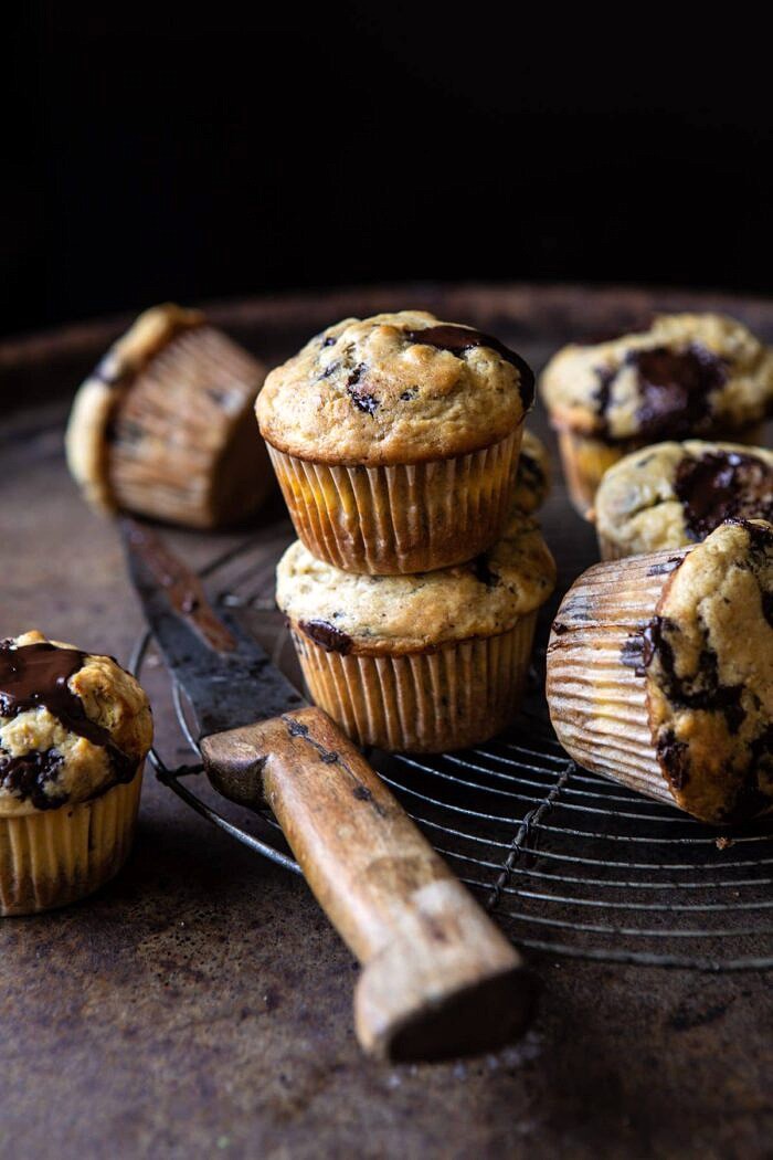 Cheesecake Stuffed Chocolate Chunk Banana Bread Muffins | halfbakedharvest.com #muffins #cheesecake #bananamuffin #dessert side angled photo of Cheesecake Stuffed Chocolate Chunk Banana Bread Muffins