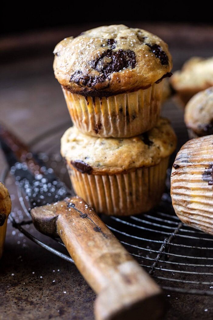 Cheesecake Stuffed Chocolate Chunk Banana Bread Muffins | halfbakedharvest.com #muffins #cheesecake #bananamuffin #dessert side angled close up photo of Cheesecake Stuffed Chocolate Chunk Banana Bread Muffins