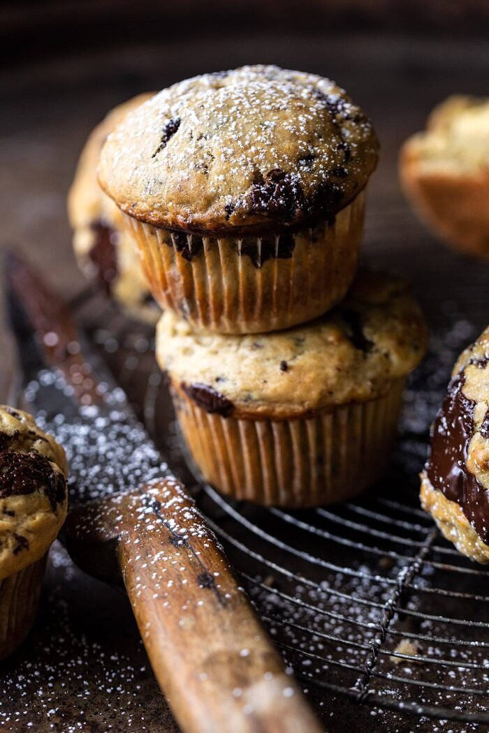 Cheesecake Stuffed Chocolate Chunk Banana Bread Muffins | halfbakedharvest.com #muffins #cheesecake #bananamuffin #dessert close up photo of Cheesecake Stuffed Chocolate Chunk Banana Bread Muffins 2 stacked on each other