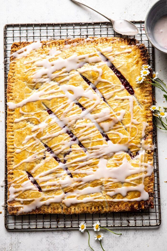 Giant Strawberries n' Cream Pop Tart | halfbakedharvest.com #brunch #pie #dessert #breakfast Giant Strawberries n' Cream Pop Tart after baking drizzled with glaze