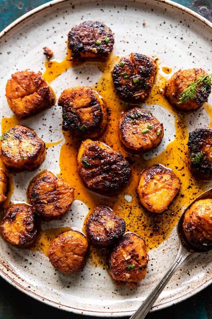 Honey Butter Blackened Scallops with Herby Polenta | halfbakedharvest.com #seafood #scallops #easyrecipes #dinnerrecipes Honey Butter Blackened Scallops on plate
