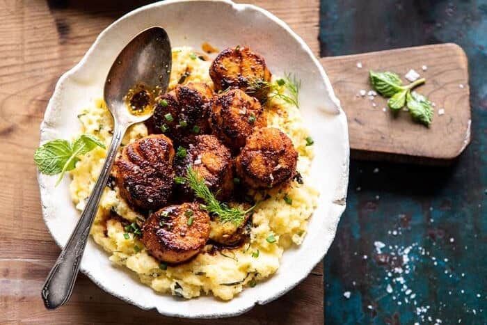 Honey Butter Blackened Scallops with Herby Polenta | halfbakedharvest.com #seafood #scallops #easyrecipes #dinnerrecipes overhead horizontal photo of Honey Butter Blackened Scallops with Herby Polenta