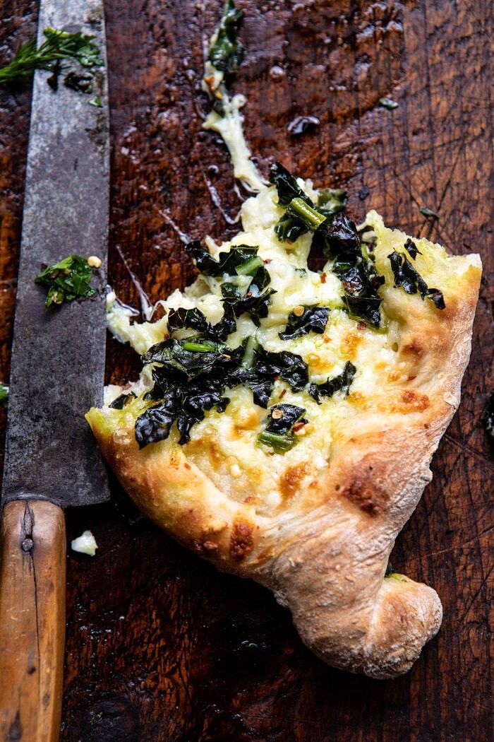 single piece of Khachapuri (Georgian Cheese Bread) with Kale and Herb Sauce