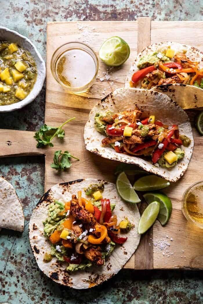 30 Minute Chicken Fajitas with Roasted Pineapple Salsa Verde | halfbakedharvest.com #chickenrecipes #mexicanrecipes #dinner #fajitas #healthyrecipes overhead photo of 30 Minute Chicken Fajitas with Roasted Pineapple Salsa Verde with beer glasses and salsa in photo