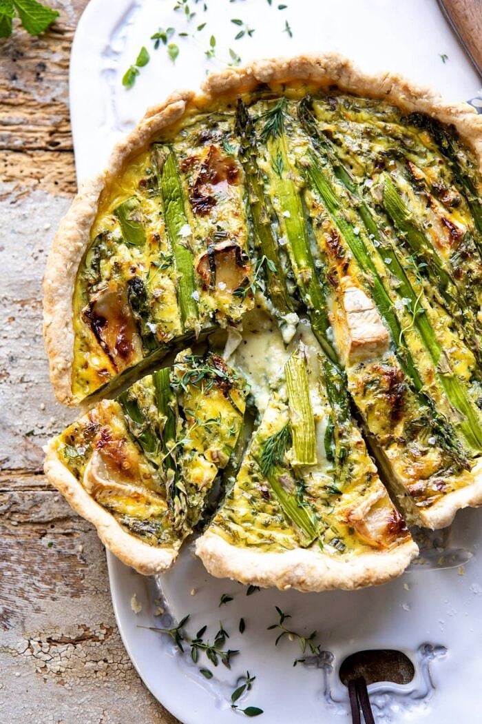 Asparagus and Brie Quiche | halfbakedharvest.com #quiche #brunch #springrecipes #easter overhead photo of Asparagus and Brie Quiche with 2 slices cut