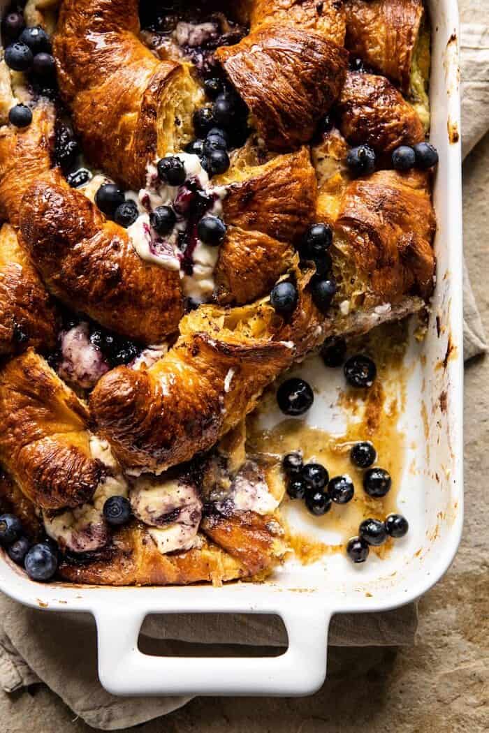 Berry and Cream Cheese Croissant French Toast Bake | halfbakedharvest.com #frenchtoast #brunch #easyrecipes #springrecipes #easter overhead photo of Berry and Cream Cheese Croissant French Toast Bake with serving piece taken out