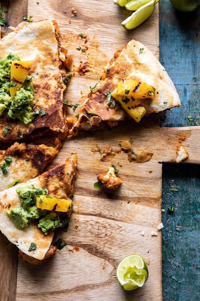 Cauliflower Al Pastor Quesadillas with Lime Smashed Avocado | halfbakedharvest.com #vegan #Mexican #cauliflower #pineapple #sandwich #easyrecipes #cheese overhead photo of Cauliflower Al Pastor Quesadillas with Lime Smashed Avocado half eaten