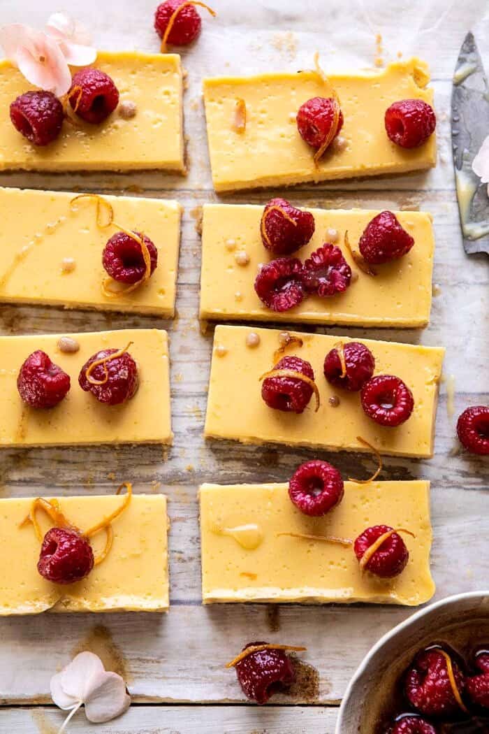 Creamy Lemon Bars with Browned Butter Raspberries | halfbakedharvest.com #lemon #brownbutter #spring #summer #easter #mothersday #brunch #dessert close up overhead photo of Creamy Lemon Bars with Browned Butter Raspberries
