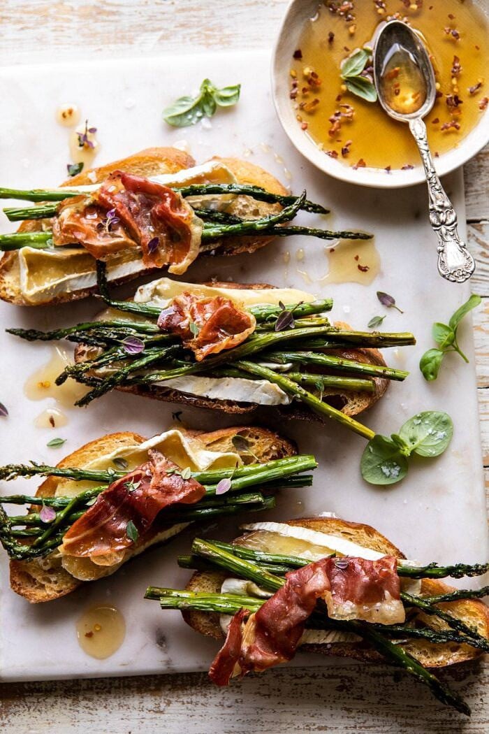 Crispy Prosciutto, Asparagus, and Brie Toast | halfbakedharvest.com #easyrecipes #appetizers #brie #mothersday #spring #summer overhead photo of Crispy Prosciutto, Asparagus, and Brie Toast with hot honey in photo