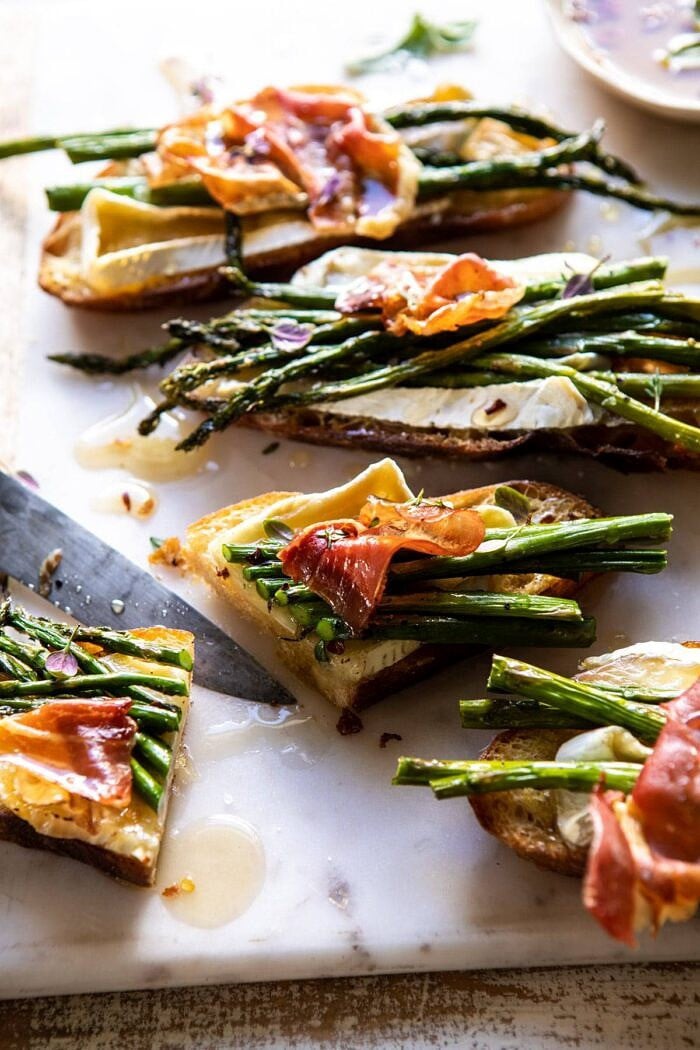 Crispy Prosciutto, Asparagus, and Brie Toast | halfbakedharvest.com #easyrecipes #appetizers #brie #mothersday #spring #summer side angled photo of Crispy Prosciutto, Asparagus, and Brie Toast cut in half