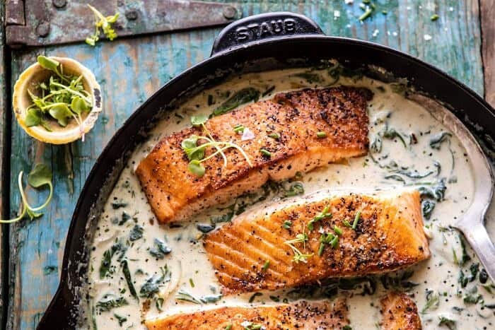 Garlic Butter Creamed Spinach Salmon | halfbakedharvest.com #salmon #easyrecipes #seafood #dinner horizontal photo of Garlic Butter Creamed Spinach Salmon in skillet