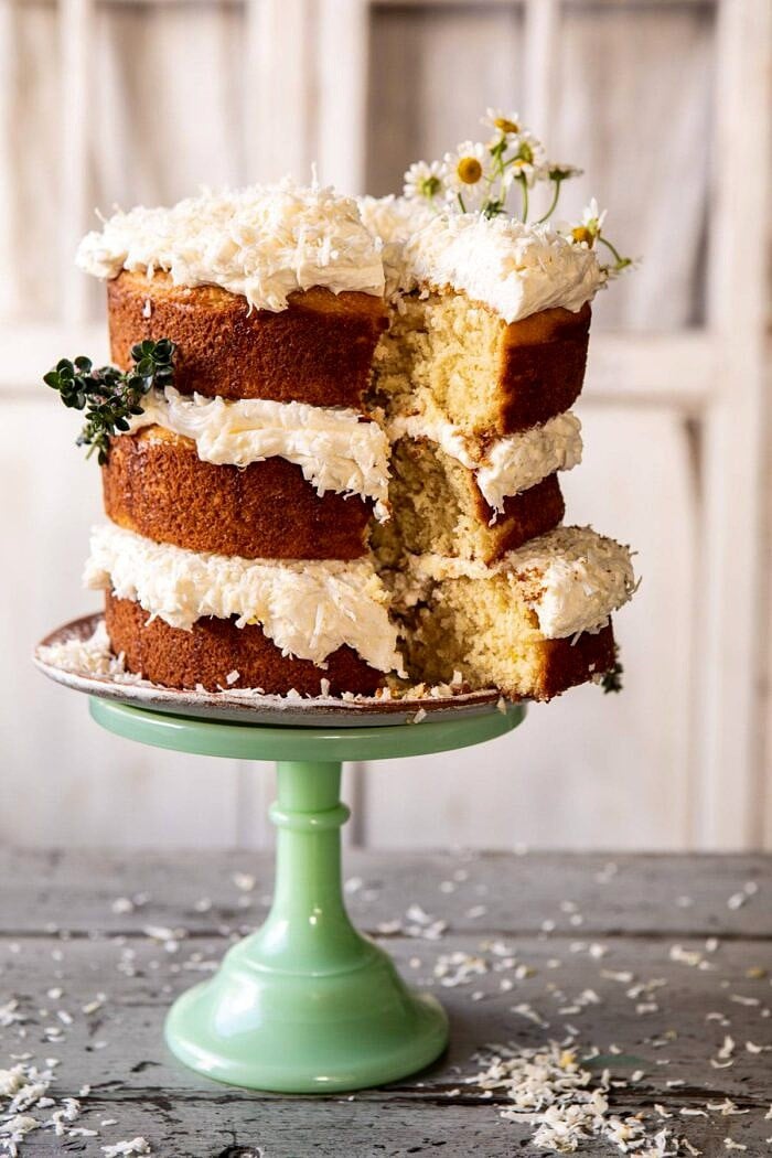 Lemon Coconut Naked Cake with Whipped Vanilla Buttercream | halfbakedharvest.com #coconutcake #springrecipes #easter #cake #layercake Lemon Coconut Naked Cake with Whipped Vanilla Buttercream with slice cut