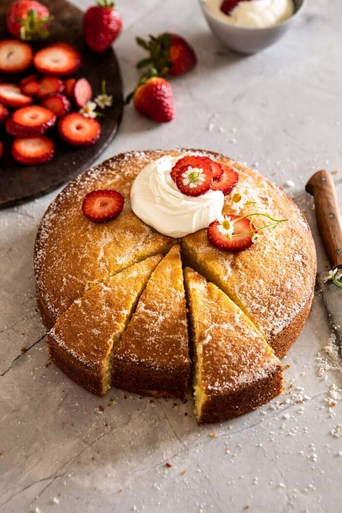 Strawberry Chamomile Olive Oil Cake with Honeyed Ricotta | halfbakedharvest.com #cake #dessert #springrecipes #Easter #strawberry side angled photo of Strawberry Chamomile Olive Oil Cake with Honeyed Ricotta and 3 slices cut