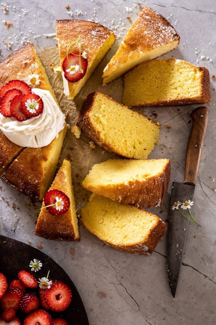 Strawberry Chamomile Olive Oil Cake with Honeyed Ricotta | halfbakedharvest.com #cake #dessert #springrecipes #Easter #strawberry over head photo ofo Strawberry Chamomile Olive Oil Cake with Honeyed Ricotta and 8 slices cut from cake and knife in photo