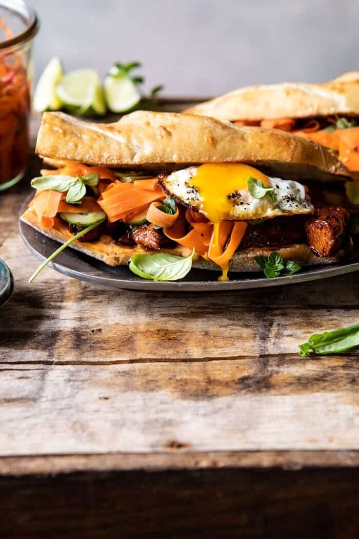 30 Minute Basil Chicken Banh Mi Sandwich | halfbakedharvest.com #easyrecipe #healthyrecipes #chicken #thai #Vietnamese front on photo of 30 Minute Basil Chicken Banh Mi Sandwich with egg broken and yolk running