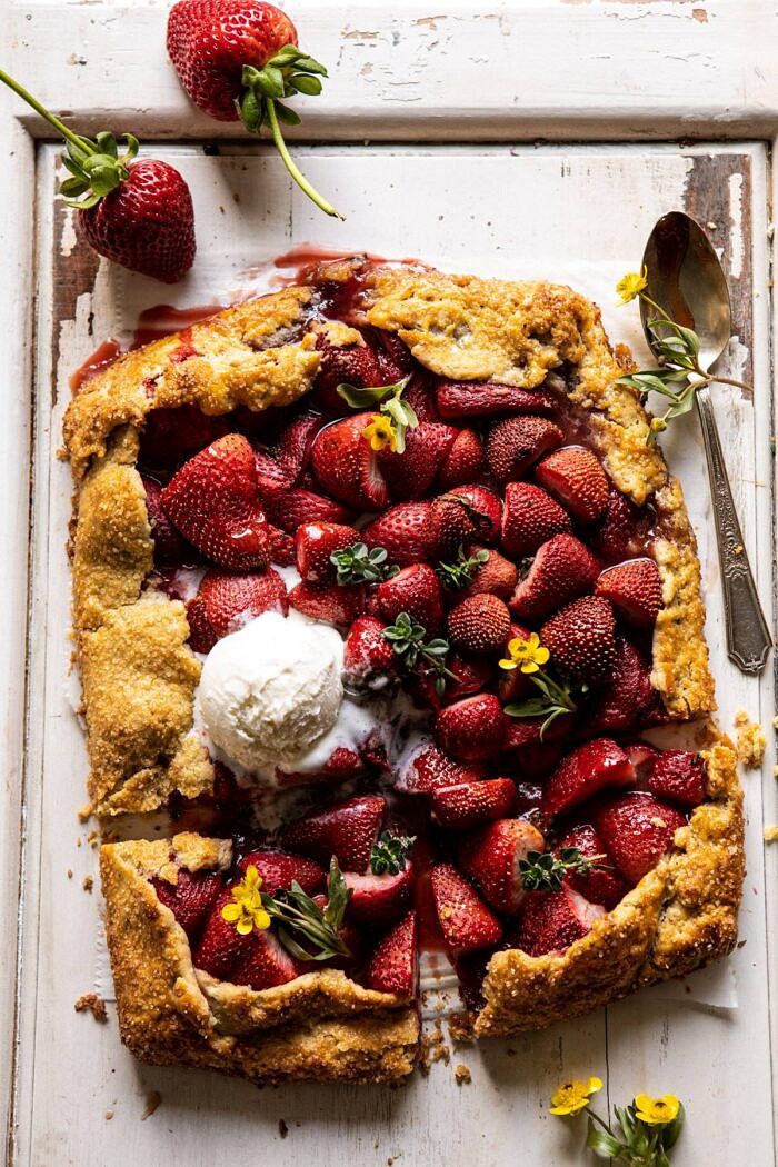Jammy Strawberry Galette | halfbakedharvest.com #strawberries #tart #summer #fruit #springrecipes overhead photo of Jammy Strawberry Galette with ice cream and 2 pieces cut