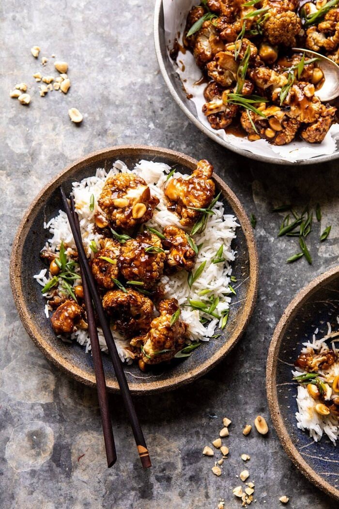 overhead photo of Better Than Takeout Kung Pao Cauliflower in a bowl with rice and chopsticks