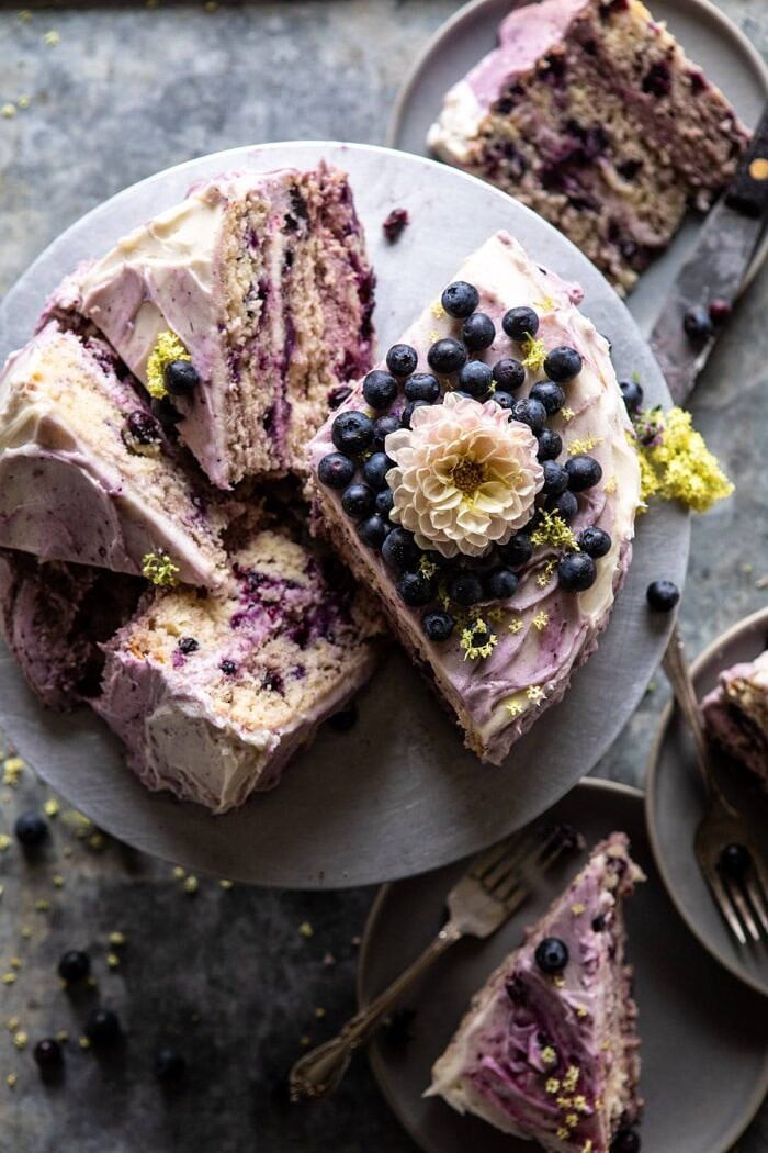 Bursting Blueberry Lemon Layer Cake | halfbakedharvest.com #bleberrycake #layercake #summerrecipes #dessert overhead photo of Bursting Blueberry Lemon Layer Cake with slices cut