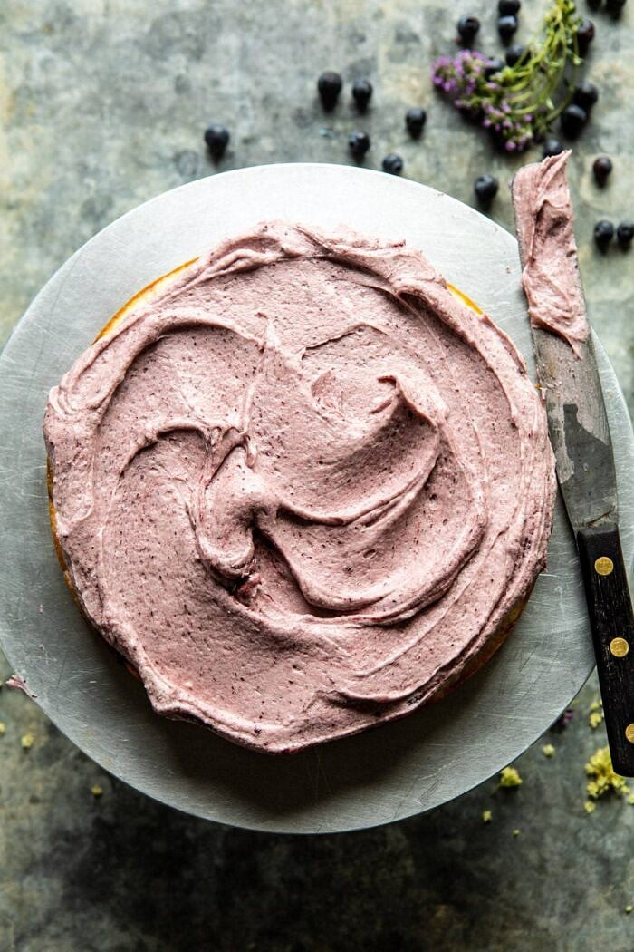 Bursting Blueberry Lemon Layer Cake | halfbakedharvest.com #bleberrycake #layercake #summerrecipes #dessert 1st cake layer with buttercream