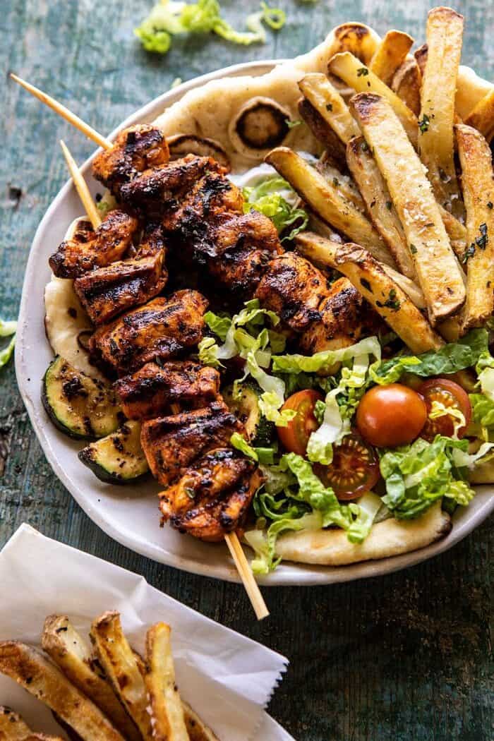 Chicken Souvlaki Bowls with Garlic Fries | halfbakedharvest.com #greek #healthyrecipes #dinner #summerrecipes overhead close up photo of Chicken Souvlaki Bowls with Garlic Fries