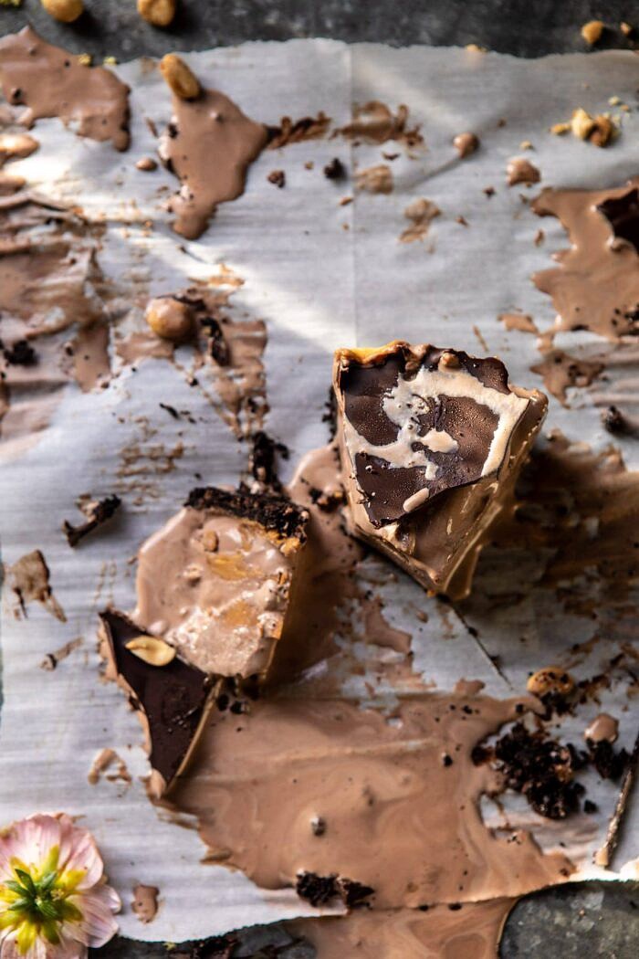 Nonnie's 6 Ingredient Chocolate Peanut Butter Ice Cream Cake | halfbakedharvest.com #icecream #easyrecipes #chocolate #peanutbutter #summer overhead photo of Nonnie's 6 Ingredient Chocolate Peanut Butter Ice Cream Cake slices melting on parchment paper