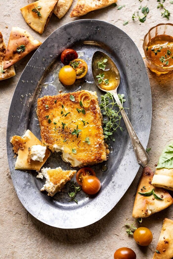 Pan-Fried Feta with Peppered Honey | halfbakedharvest.com #appetizers #easyrecipes #summerrecipes overhead photo of Pan-Fried Feta with Peppered Honey and tomatoes on plate with spoon
