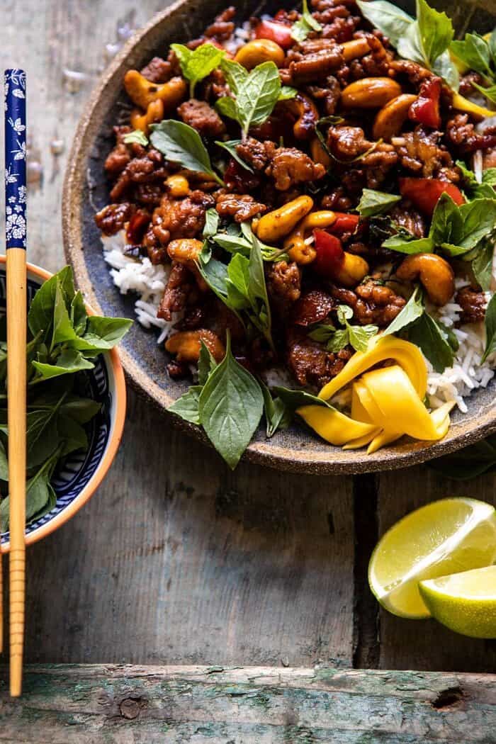 Better Than Takeout Sweet Thai Basil Chicken | halfbakedharvest.com #easyrecipes #20minutes #thaichicken #ricebowl #healthy side angle close up photo of Better Than Takeout Sweet Thai Basil Chicken