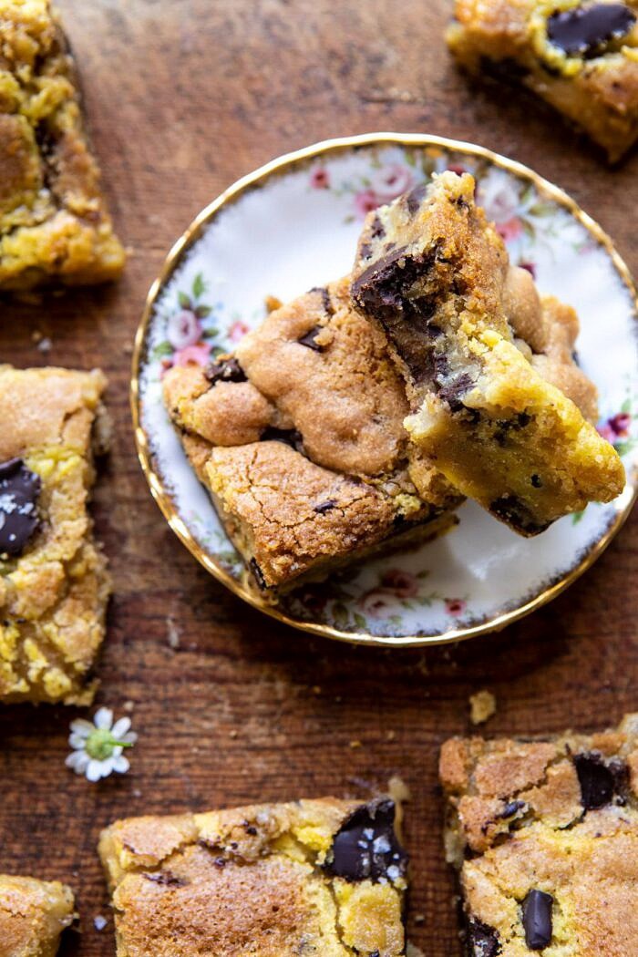 Crème Fraîche Chocolate Chunk Cookie Bars | halfbakedharvest.com #cookies #chocolatechipcookies #cookiebar overhead close up photo of Crème Fraîche Chocolate Chunk Cookie Bar with bite taken out of bar on plate
