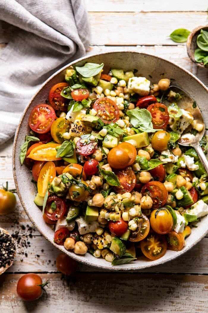 Corn, Tomato, and Avocado Chickpea Salad | halfbakedharvest.com #healthy #tomatosalad #quick #mealprep overhead close up photo of Corn, Tomato, and Avocado Chickpea Salad after tossing