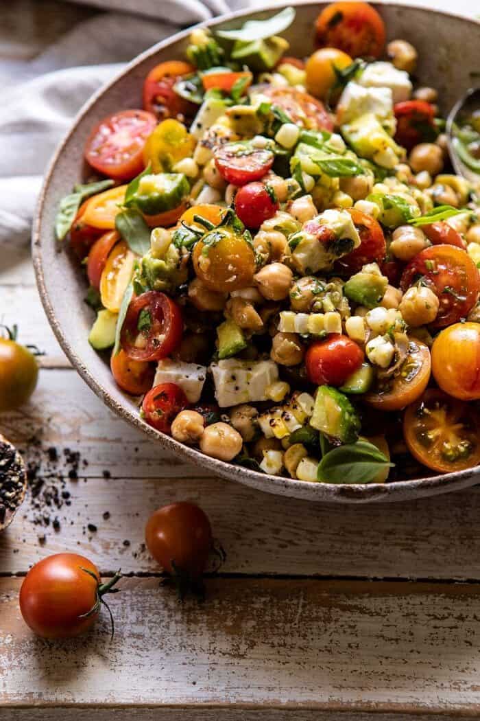 Corn, Tomato, and Avocado Chickpea Salad | halfbakedharvest.com #healthy #tomatosalad #quick #mealprep side angled photo of Corn, Tomato, and Avocado Chickpea Salad after tossing