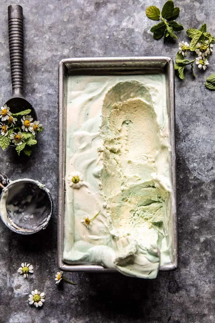 No Churn Minted White Chocolate Swirled Ice Cream | halfbakedharvest.com #icecream #easyrecipes #dessert #nochurnicecream overhead photo of No Churn Minted White Chocolate Swirled Ice Cream with multiple scoops of ice cream removed from container