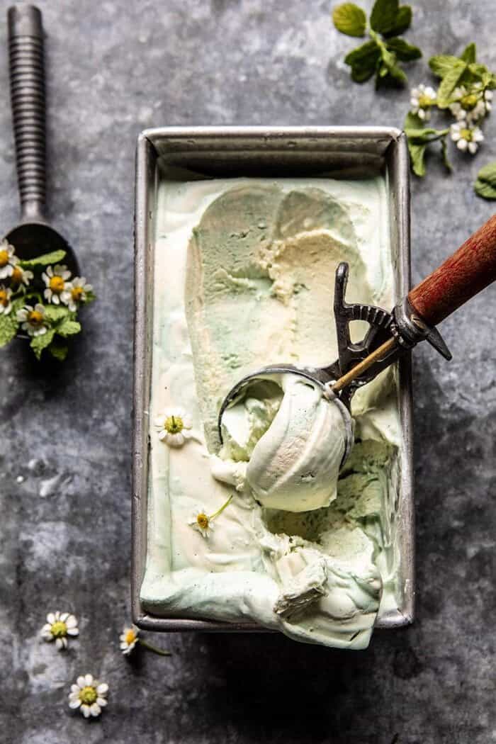 No Churn Minted White Chocolate Swirled Ice Cream | halfbakedharvest.com #icecream #easyrecipes #dessert #nochurnicecream overhead photo of No Churn Minted White Chocolate Swirled Ice Cream with ice cream scoop in ice cream