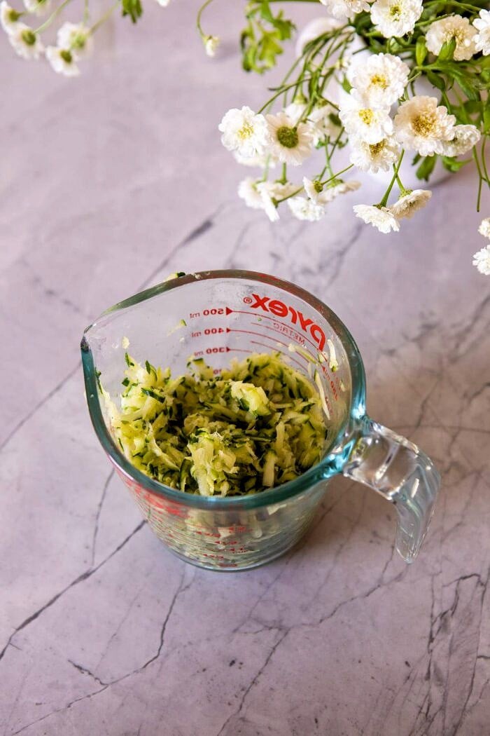 shredded zucchini in measuring cup