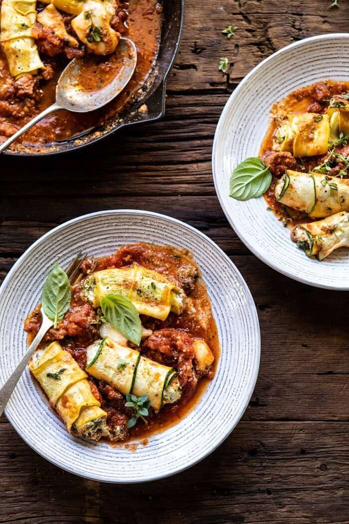 Spicy Pesto and Cheese Stuffed Zucchini Involtini | halfbakedharvest.com #zucchini #cheese #Italian #easyrecipes overhead photo of Spicy Pesto and Cheese Stuffed Zucchini Involtini on serving plates