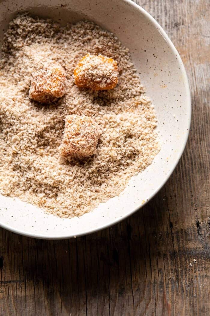 Baked Sweet Potato Parmesan Tater Tots | halfbakedharvest.com #sweetpotatoes #healthy #easyrecipes #gameday #tatertots overhead photo of sweet potato tots being rolled in bread crumbs