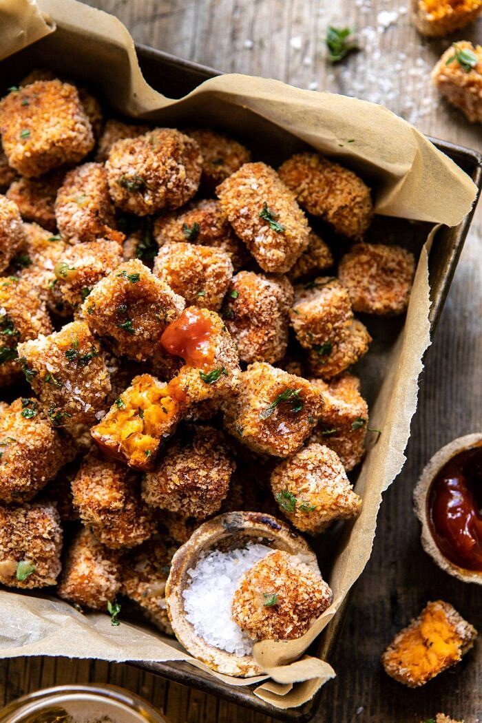 Baked Sweet Potato Parmesan Tater Tots | halfbakedharvest.com #sweetpotatoes #healthy #easyrecipes #gameday #tatertots overhead photo of Baked Sweet Potato Parmesan Tater Tots with tot broken in half and ketchup on tot