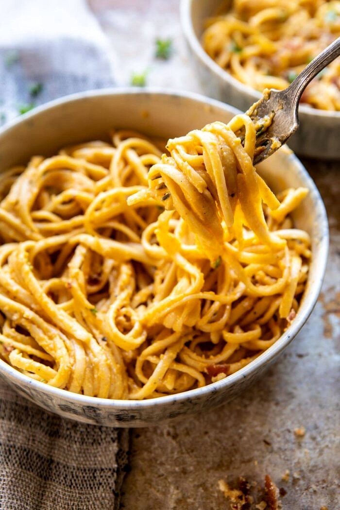 side angled photo of Creamy Butternut Squash Alla Vodka Pasta with fork coming out of bowl and pasta on fork
