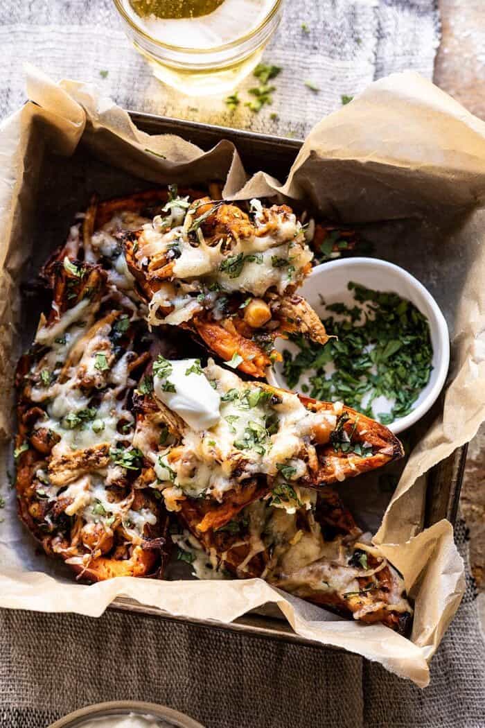 overhead photo of Healthy Chipotle Chicken Sweet Potato Skins with skins broken in half to expose the filling 