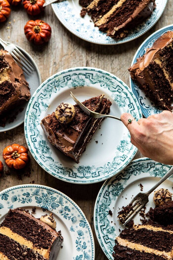 Pumpkin Patch Chocolate Peanut Butter Cake | halfbakedharvest.com #chocolatepeanutbutter #chocolatecake #peanutbutter #halloween overhead photo of Pumpkin Patch Chocolate Peanut Butter Cake slices with fork going into cake and hand in photo