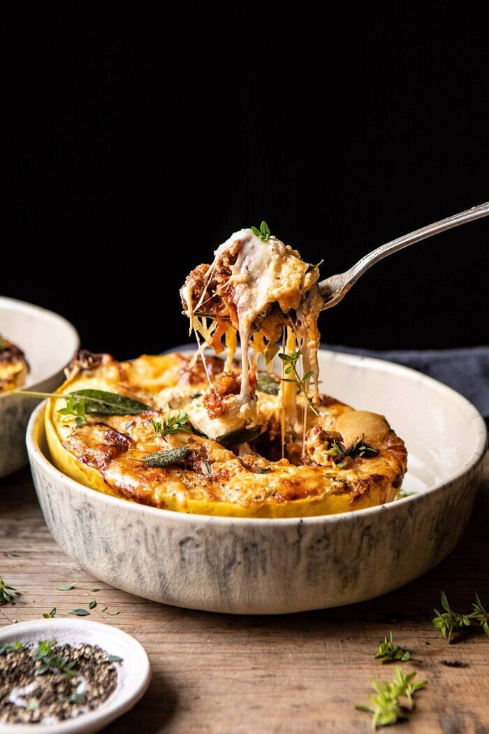 Roasted Garlic Spaghetti Squash Lasagna Boats | halfbakedharvest.com #healthyrecipes #spaghettisquash #fall #easyrecipes side angled photo of Roasted Garlic Spaghetti Squash Lasagna Boats with fork pulling up a bite of the spaghetti squash and cheese