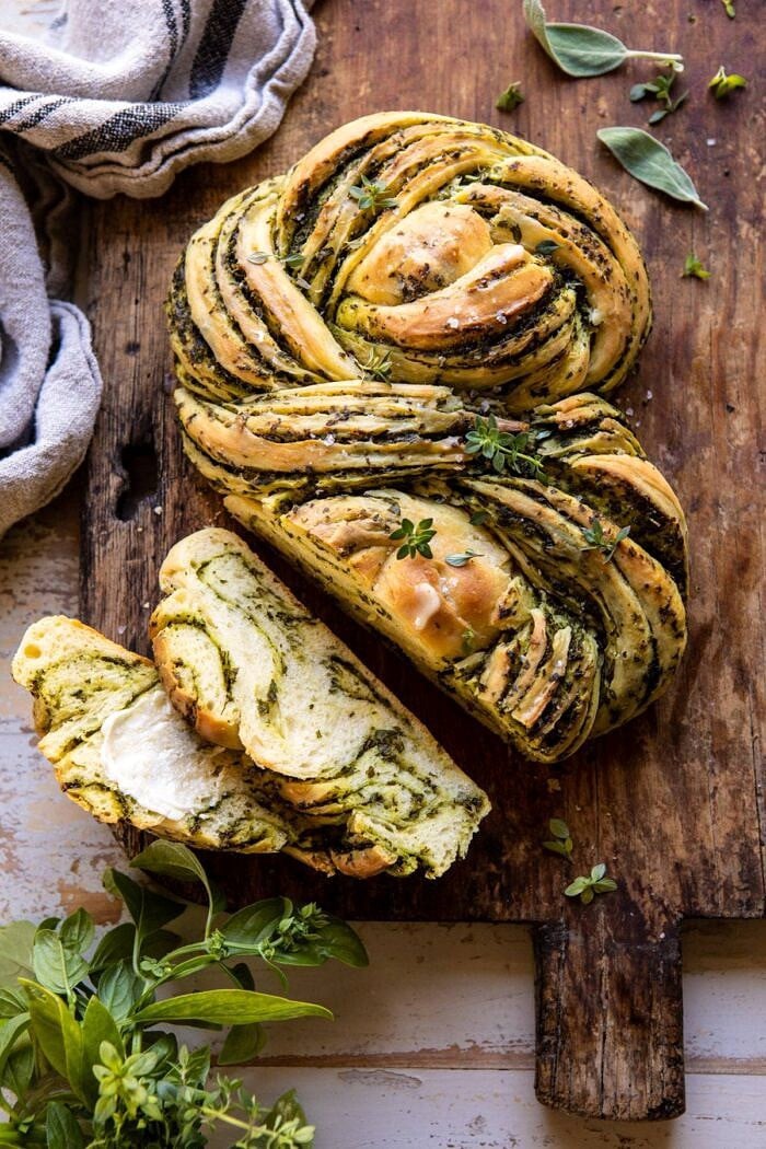 Swirled Garlic Herb Bread | halfbakedharvest.com #garlicbread #herbbread #homemadebread overhead photo of Swirled Garlic Herb Bread on cutting board with 2 pieces sliced