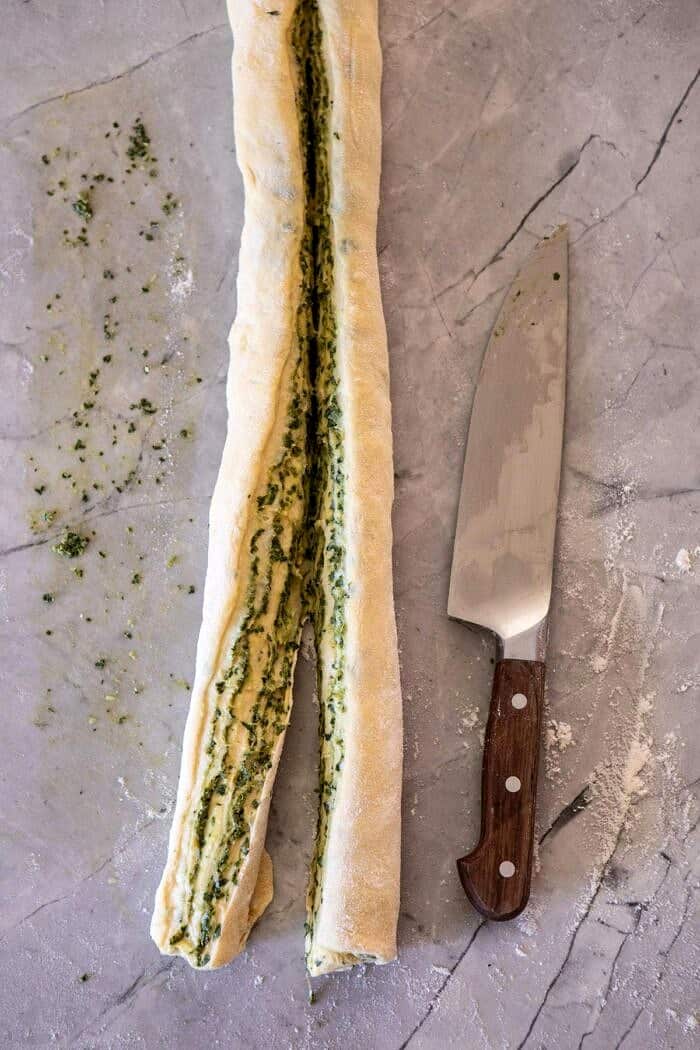 Swirled Garlic Herb Bread | halfbakedharvest.com #garlicbread #herbbread #homemadebread dough log after slicing in half lengthwise