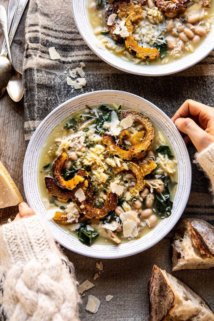 Crockpot Parmesan White Bean Chicken Soup with Roasted Delicata Squash | halfbakedharvest.com #crockpot #slowcooker #instantpot #chickensoup overhead photo Crockpot Parmesan White Bean Chicken Soup with Roasted Delicata Squash with hands on bowl