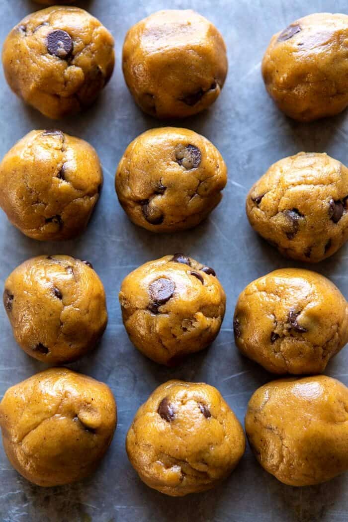 Pumpkin Butter Chocolate Chip Cookies | halfbakedharvest.com #pumpkin #cookies #chocolatechipcookies #fallrecipes overhead photo of Pumpkin Butter Chocolate Chip Cookie dough balls on baking sheet