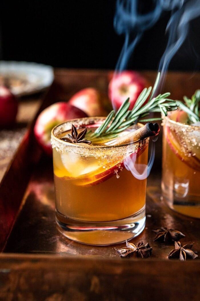 Smoky Harvest Apple Cider Margarita | halfbakedharvest.com #margarita #applecider #cocktail #holiday #thanksgiving side angled close up photo of Smoky Harvest Apple Cider Margarita with smoking cinnamon stick