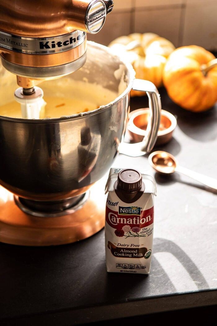 Burnt Basque Pumpkin Spice Cheesecake | halfbakedharvest.com #pumpkin #cheesecake #thanksgiving side angled photo of almond milk siting next to stand mixer