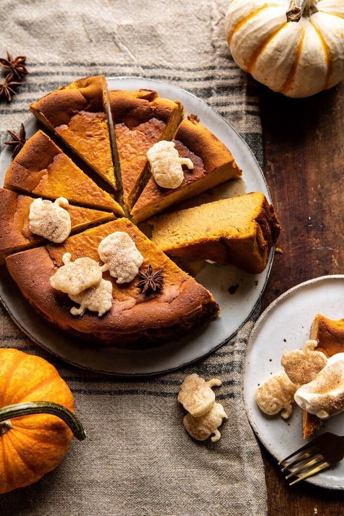 Burnt Basque Pumpkin Spice Cheesecake | halfbakedharvest.com #pumpkin #cheesecake #thanksgiving overhead photo of Burnt Basque Pumpkin Spice Cheesecake with multiple slices cut and 1 slice turned outward to show the center of cake