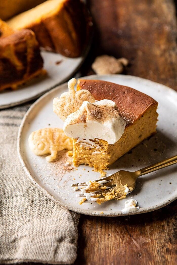 Burnt Basque Pumpkin Spice Cheesecake | halfbakedharvest.com #pumpkin #cheesecake #thanksgiving side angled photo of Burnt Basque Pumpkin Spice Cheesecake slice with bite taken out of cake