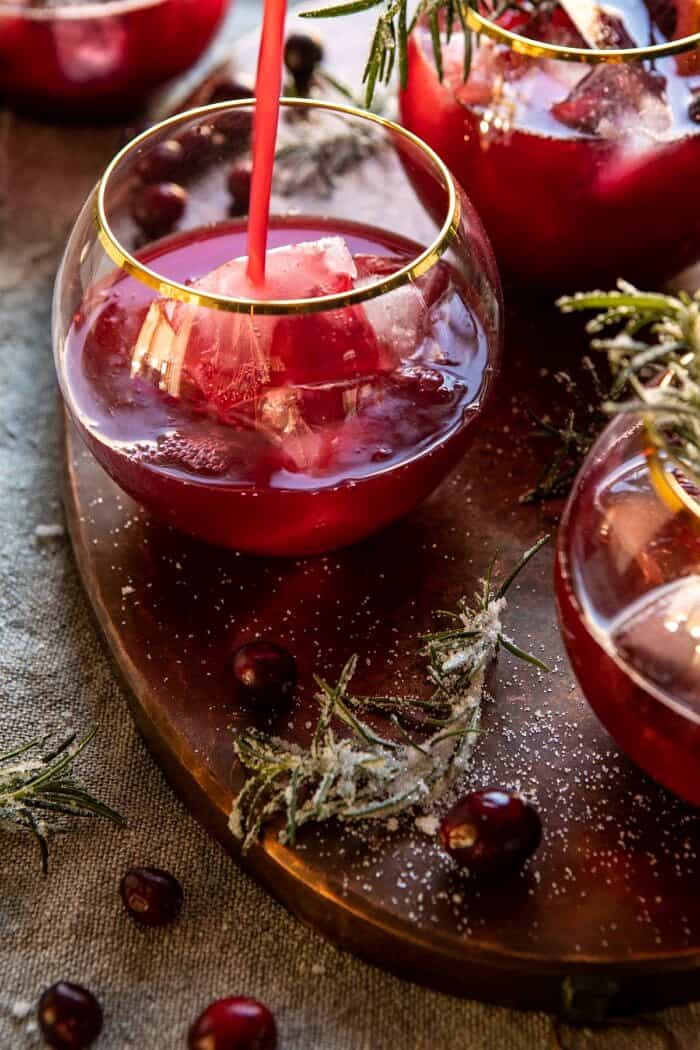 Cranberry Bourbon Sour | halfbakedharvest.com #bourbon #thanksgiving #cocktails #holiday #christmas pouring drink into glass