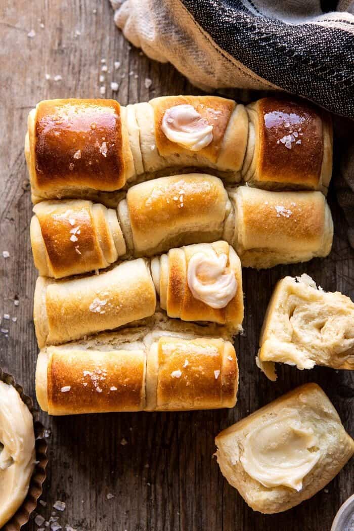 Salted Honey Butter Parker House Rolls | halfbakedharvest.com #rolls #thanksgiving #holidayrecipe overhead photo of Salted Honey Butter Parker House Rolls